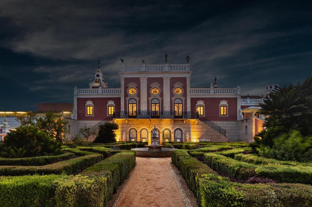a large building with a garden in front of it at Pousada Palacio de Estoi – Small Luxury Hotels of the World in Estói