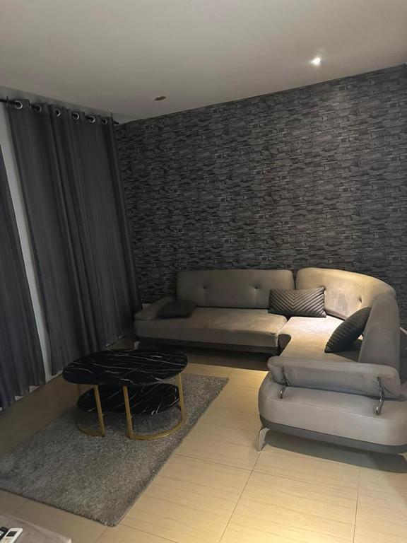 ein Wohnzimmer mit Sofa und Tisch in der Unterkunft studio Bi in Grand Médina