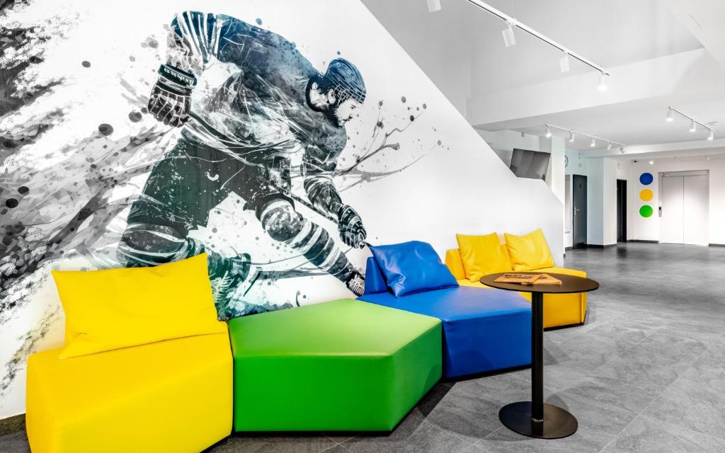 a living room with a mural of a football player at Hotel Active Stadium in Lovosice
