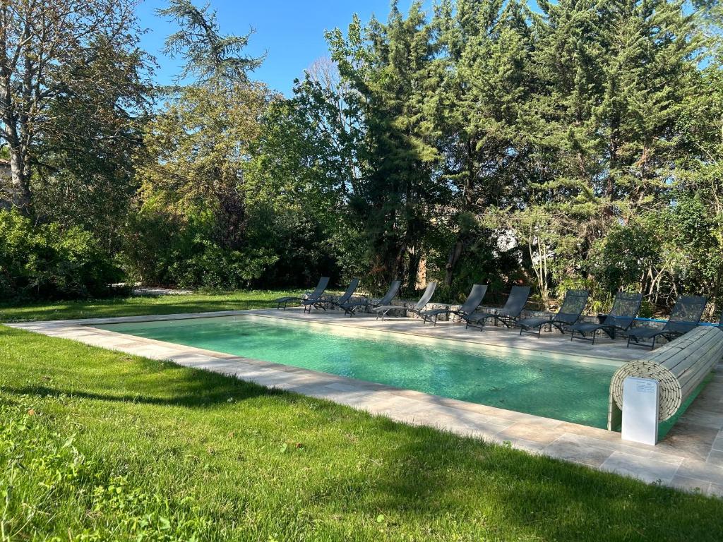 - une piscine entourée de chaises longues dans la pelouse dans l'établissement Gîte les Mercieres la Villa Maison campagne grands espaces oasis de nature, convivialité, détente 5 Chambres piscine chauffée Wifi piano billard, à Pexiora
