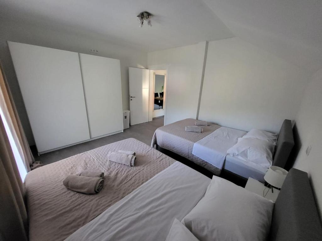 a bedroom with two beds and a television in it at Zrmanja Riverside Oasis in Bilišane