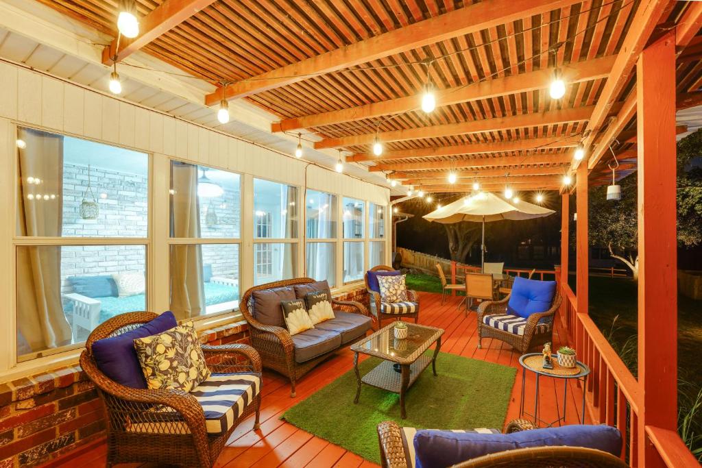 a screened in porch with furniture and an umbrella at Beaver Lake Retreat with Deck Paddle, Bike, Relax! in Springdale