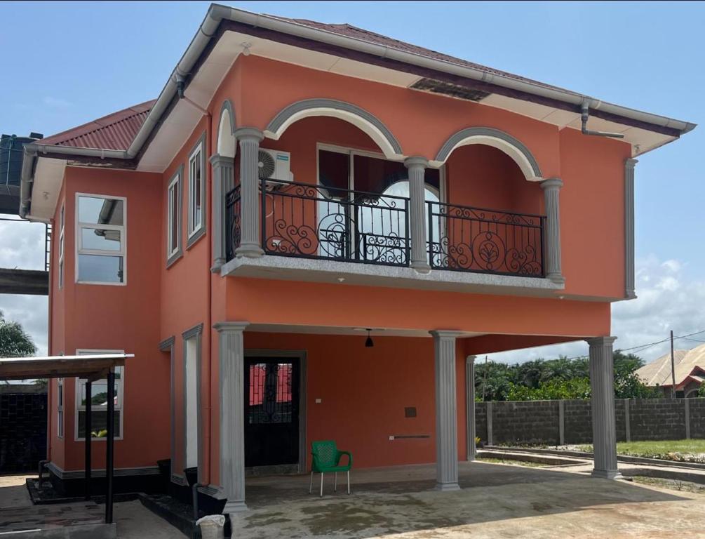 ein orangefarbenes Haus mit Balkon und Tisch in der Unterkunft Nana's Duplex Apartment in Marshall