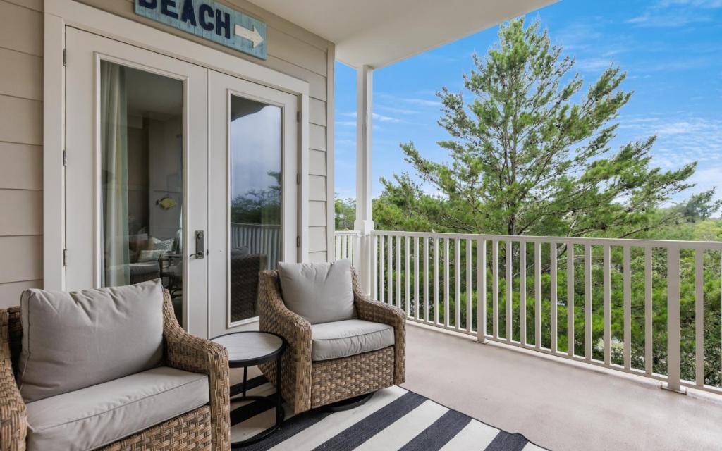 a porch with two chairs and a table on a balcony at Another Day on 30A by Oversee 30A in Santa Rosa Beach