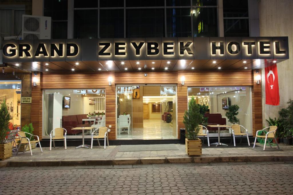 Un gran hotel con sillas y mesas delante. en Grand Zeybek Hotel, en Izmir