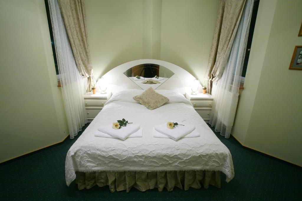 a bedroom with a white bed with flowers on it at Titanic in Białystok