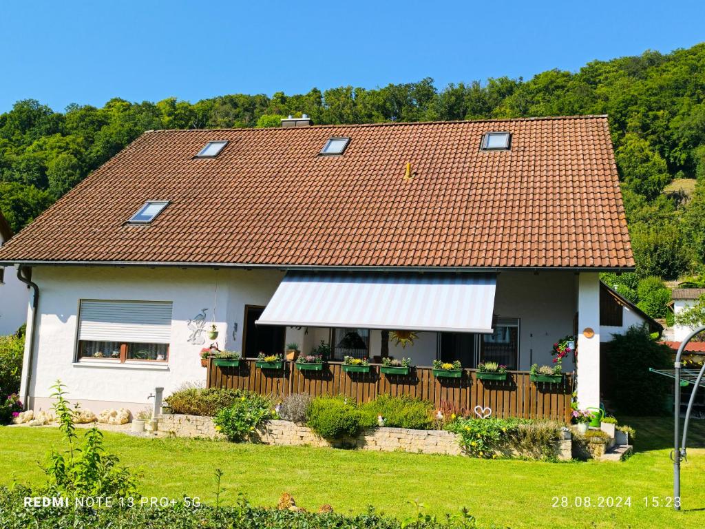 a house with a white awning and a fence at Ferienwohnung Altmühlblick in Pappenheim