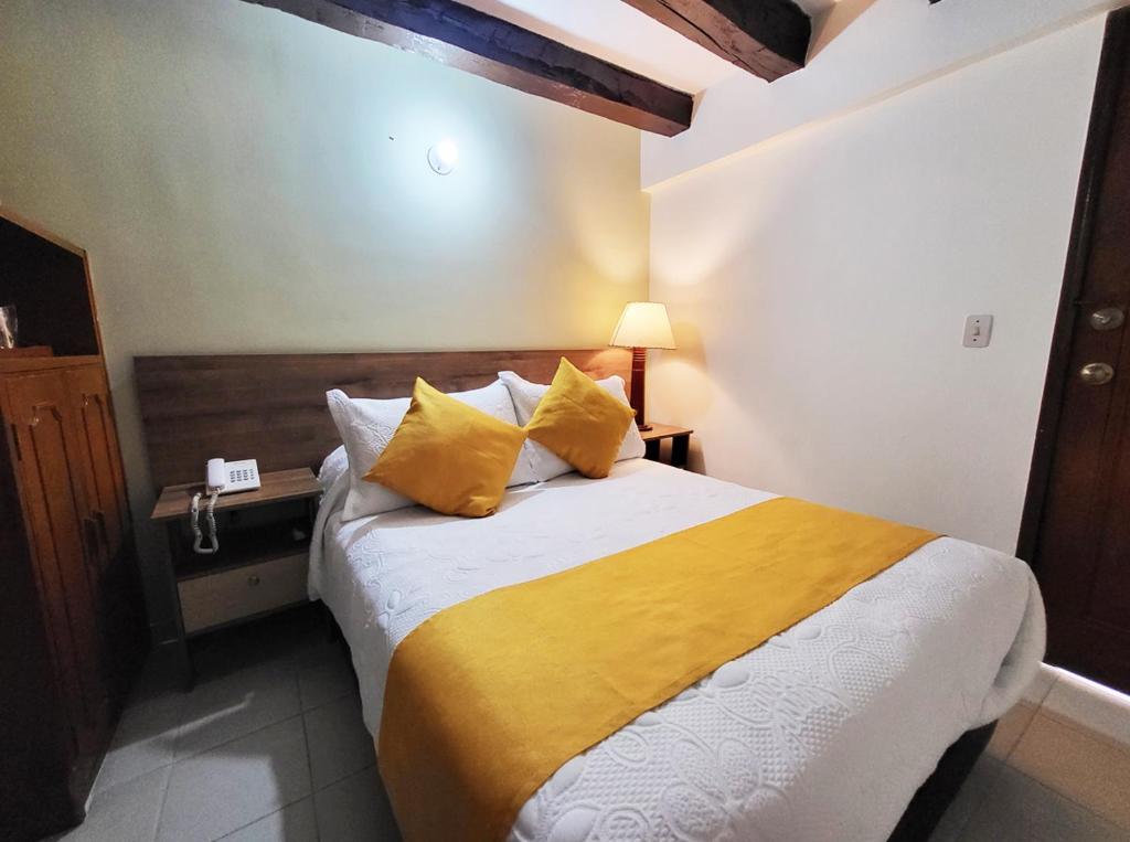 Postel nebo postele na pokoji v ubytování Hotel Ambala Bogota Colonial