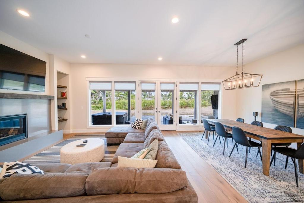 a living room with a couch and a table at Gearhart Getaway - Gated Community Home w/ Hot Tub, Walk to Beach in Warrenton