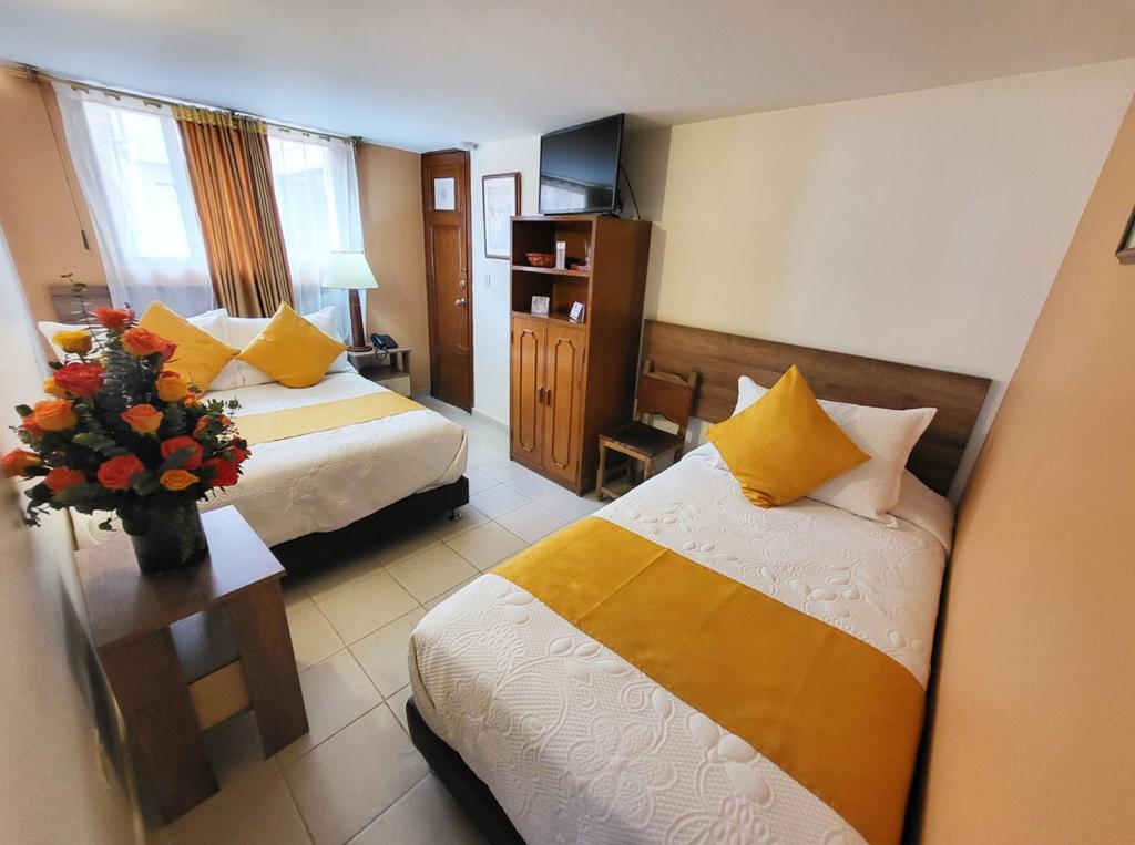 Postel nebo postele na pokoji v ubytování Hotel Ambala Bogota Colonial