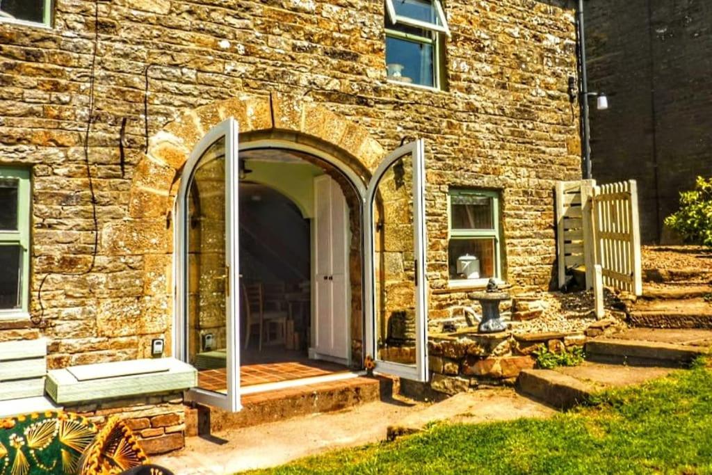 an entrance to a brick building with an open door at Butterfly Lodge quirky rural home stunning views in Bishop Auckland
