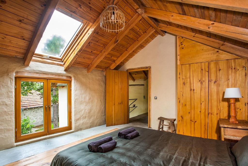 a bedroom with a large bed in a wooden house at Guest House Podkovite in Karlovo