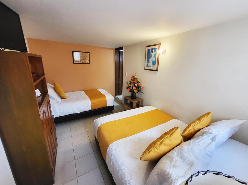 Postel nebo postele na pokoji v ubytování Hotel Ambala Bogota Colonial