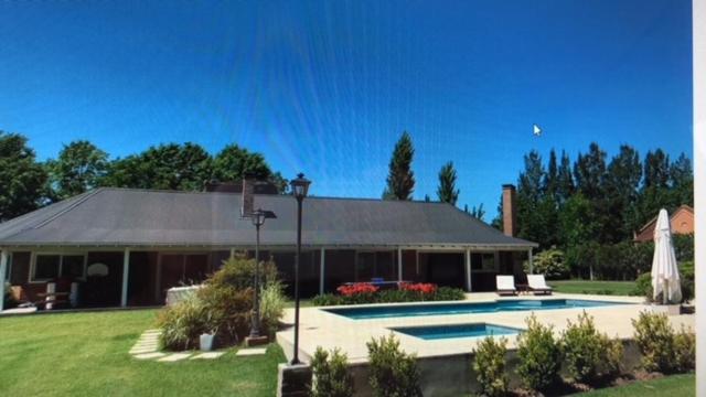 a house with a swimming pool in a yard at CONFORTABLE CASA EN HERMOSO y TRANQUILO CLUB DE CAMPO in Manzanares