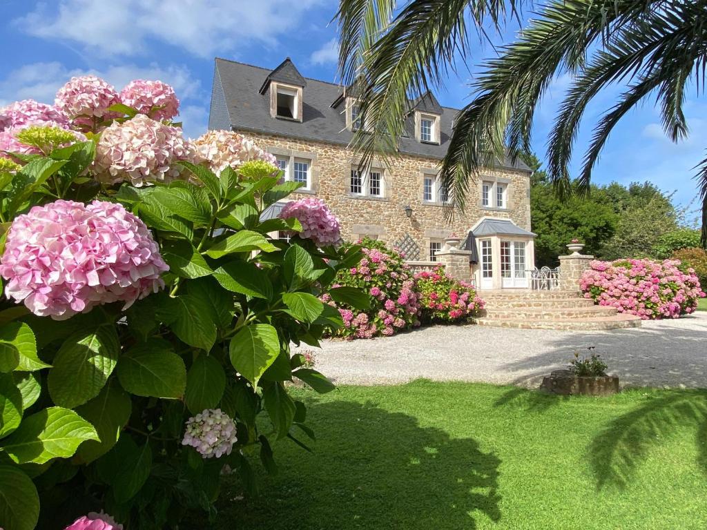 a house with pink flowers in front of it at Duplex Bellevue, vue mer, à 50m de la plage! in Réville