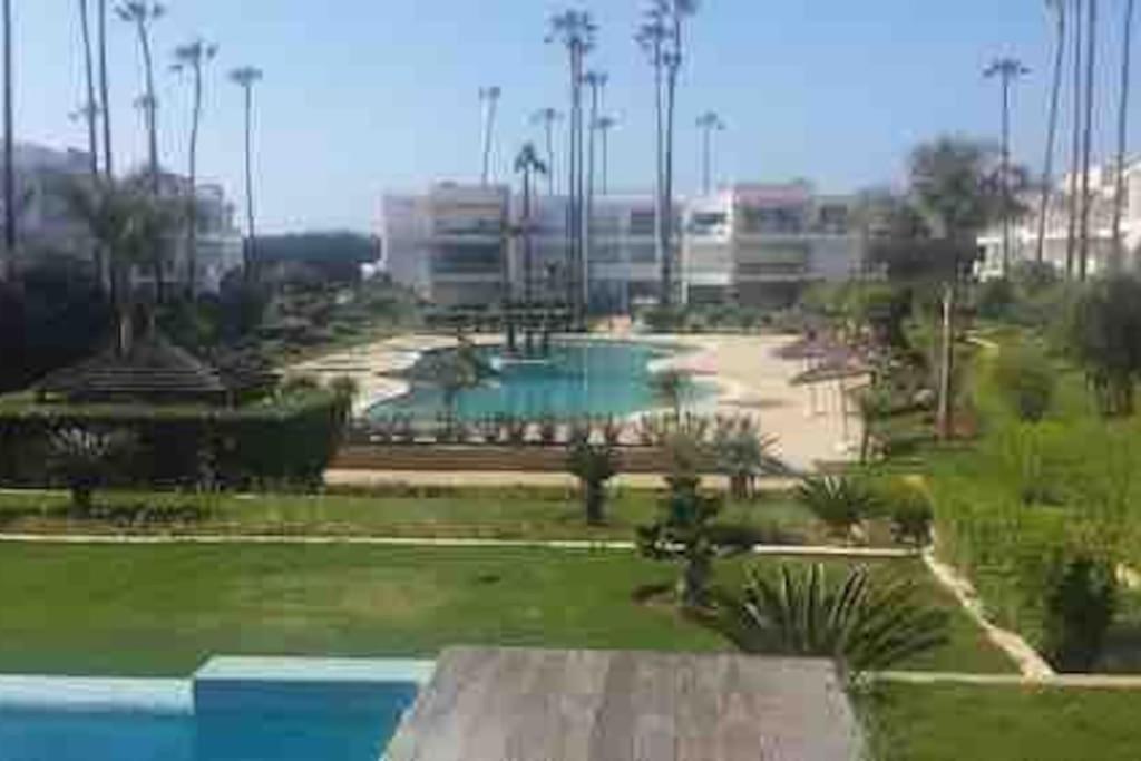 a view of a park with a swimming pool at Résidence calme et luxueuse in Dar Bouazza