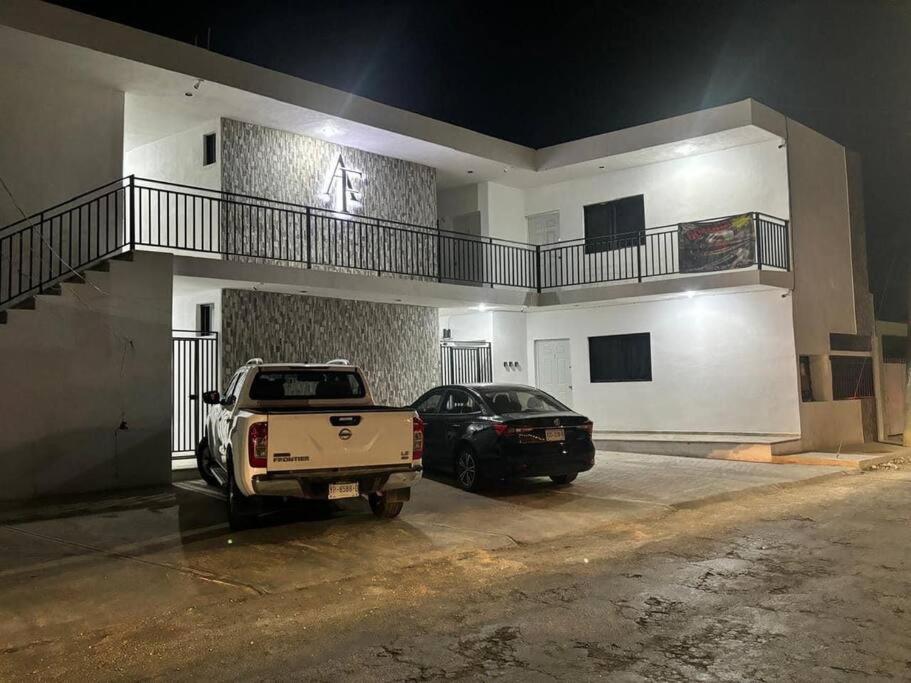 a truck and a car parked in front of a building at Departamento AF 17 in Tizimín