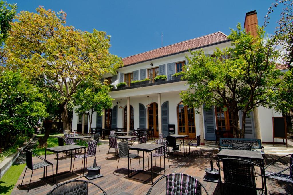 a patio with tables and chairs in front of a building at The Citizen in Antananarivo