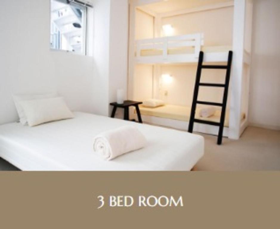 Un dormitorio con dos camas y una habitación con literas. en Second floor - Vacation STAY 83098v, en Naha