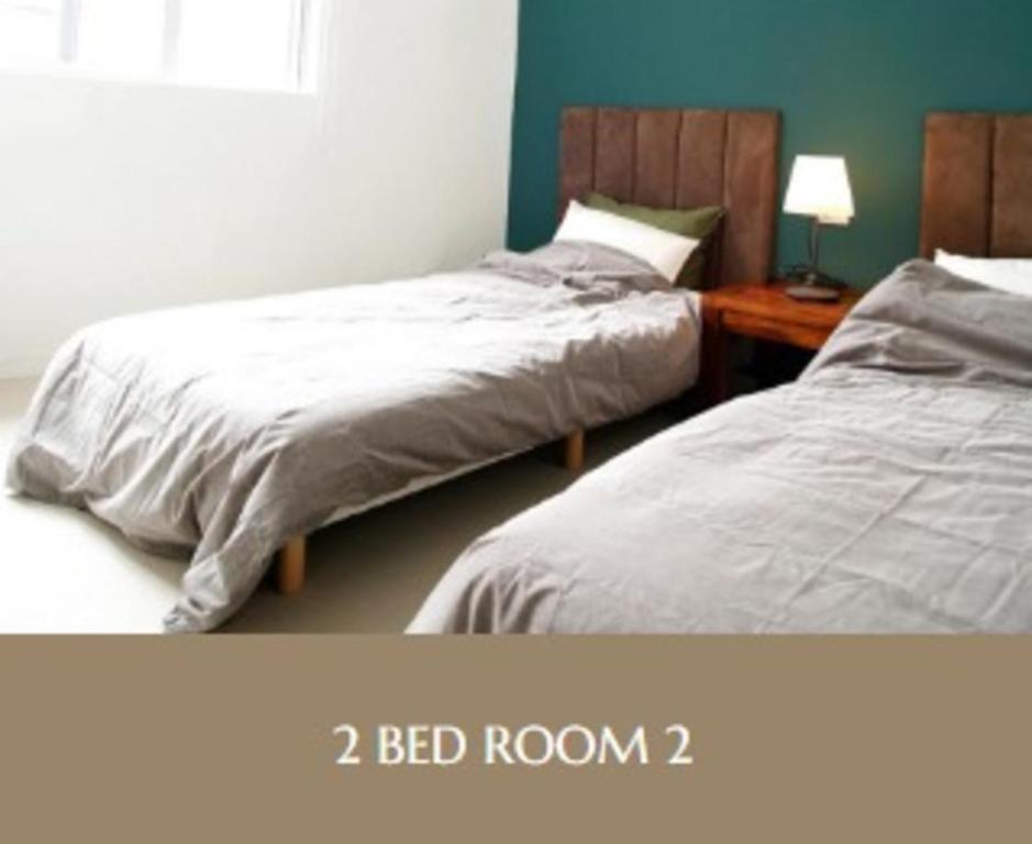 a bedroom with two beds and a bed at Second floor - Vacation STAY 82648v in Naha