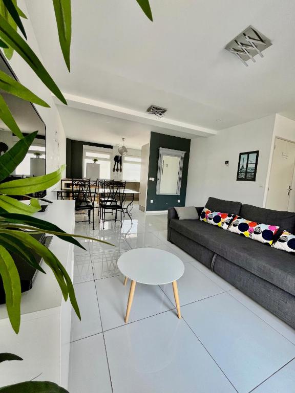 un salon avec un canapé et une table dans l'établissement Maison Lilouma Disneyland Paris, à Montévrain