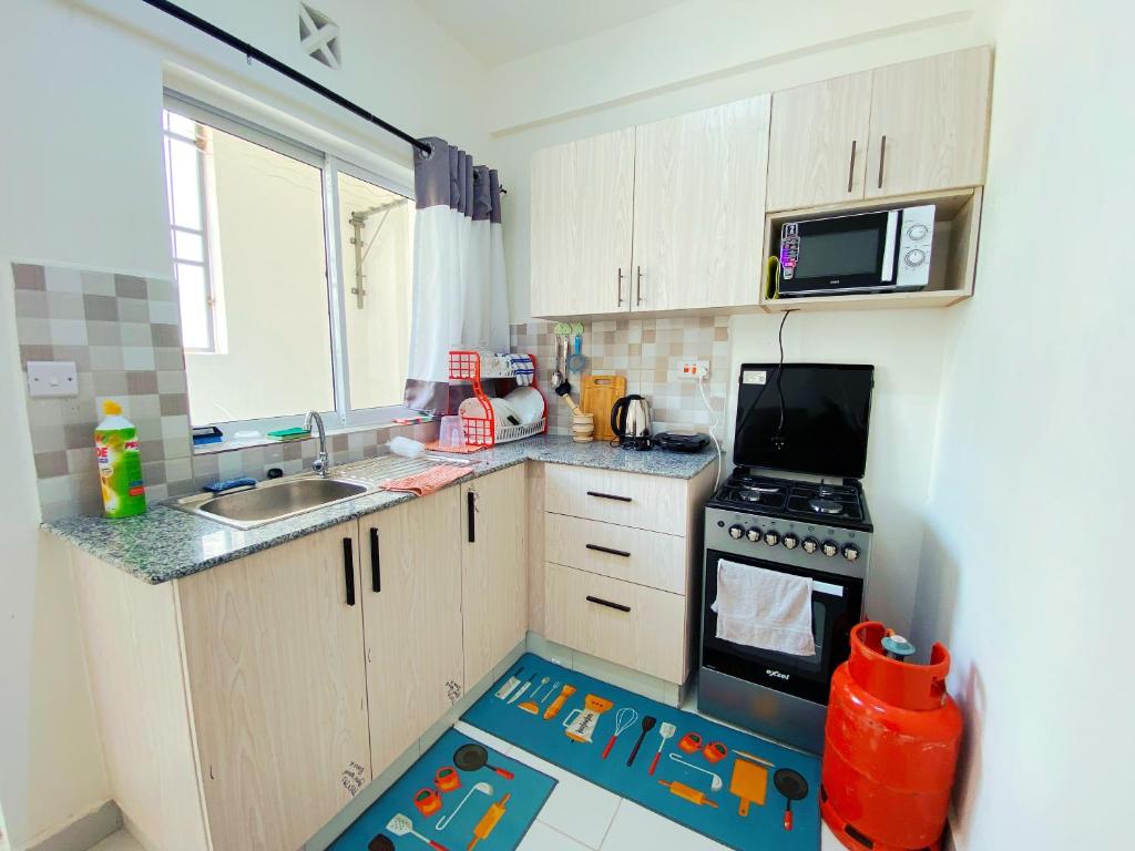 eine kleine Küche mit einer Spielmatte in der Mitte in der Unterkunft Three Bedroom A2 Buxton Mombasa in Mombasa