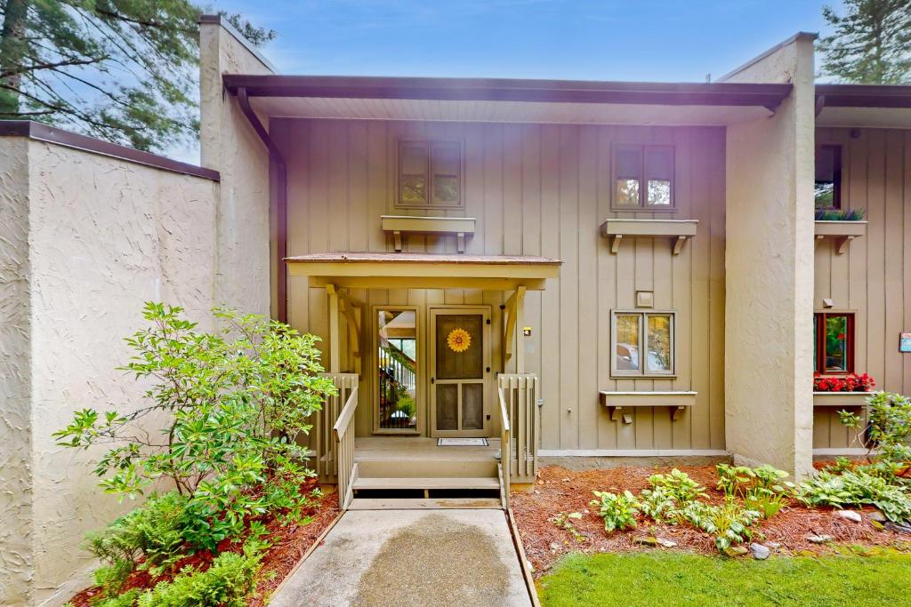 a house with a door and a porch with a yard at Mountain Lea Hideaway in Sapphire