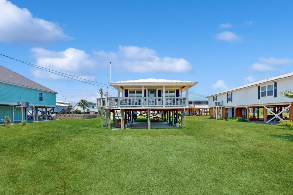 a house with a porch on a grass yard at Macs Fish Camp in Dauphin Island