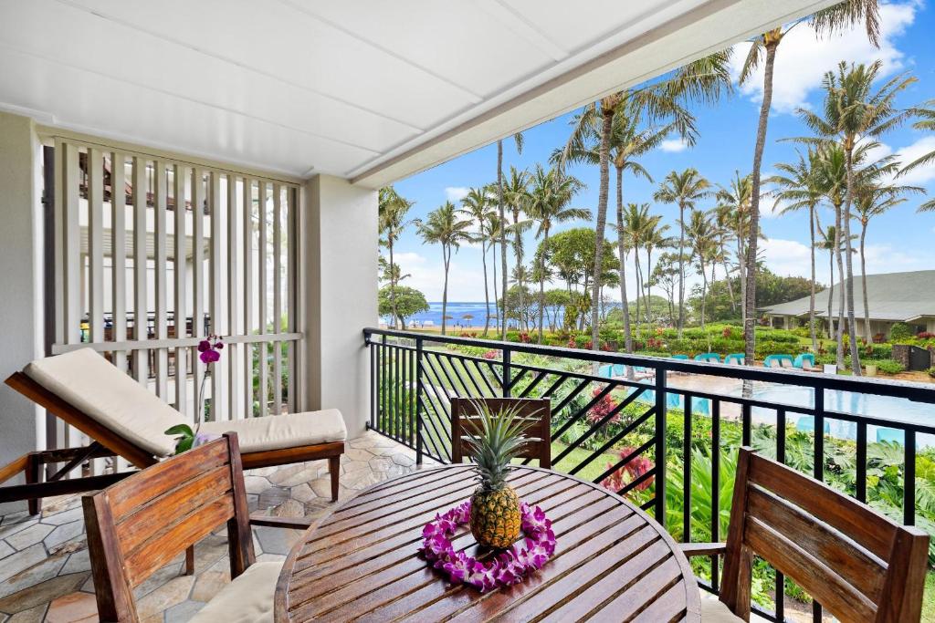 un balcón con una mesa con una piña. en 3-Bed Villa 208 at Turtle Bay, en Kahuku