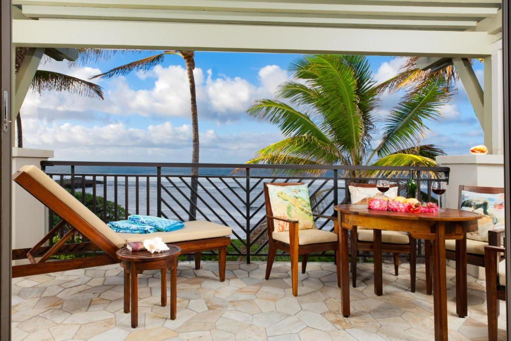 balcone con sedie, tavolo e vista sull'oceano di 4-Bed Combination Villa 316-317 Turtle Bay a Kahuku