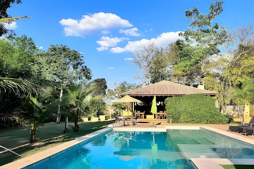 a swimming pool with a gazebo and a resort at Casa Charme no Centro de Bonito in Bonito