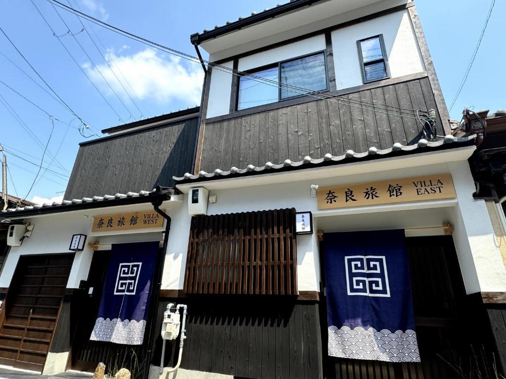 a building with blue doors and writing on it at Villa East West - Vacation STAY 18083v in Nara