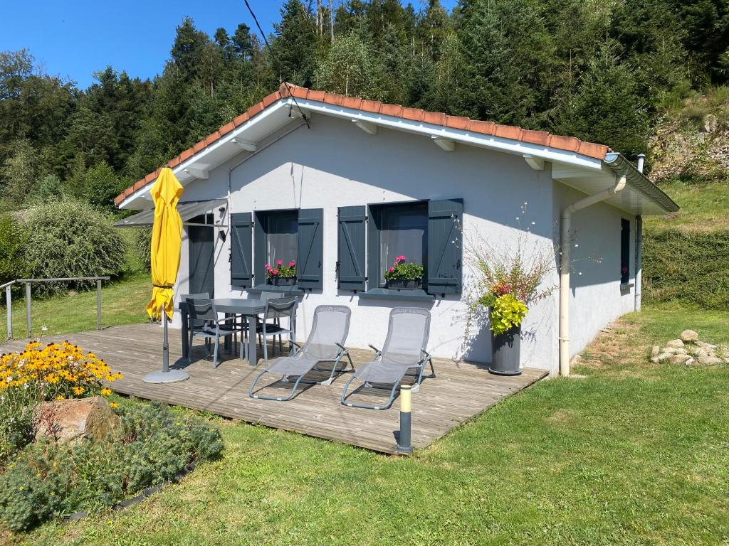 ein Haus mit einer Terrasse mit einem Tisch und Stühlen in der Unterkunft La Maison Bleue in Saint-Étienne-lès-Remiremont