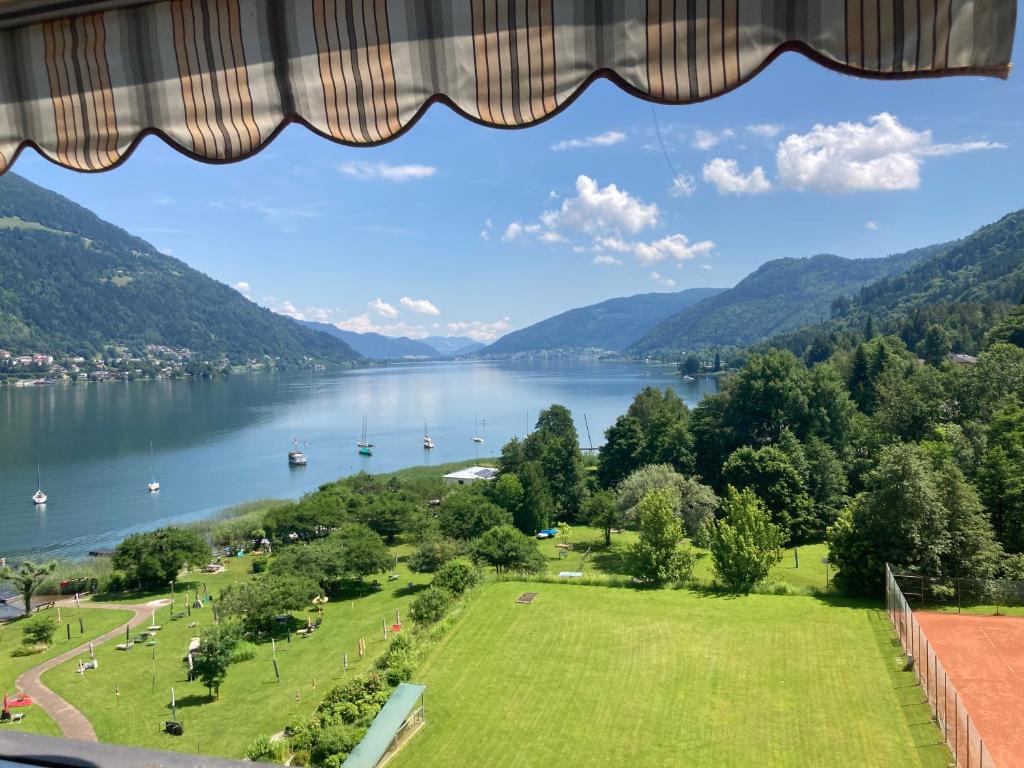 a view of a lake from a window at Apartment mit Seeblick & Seezugang in Villach