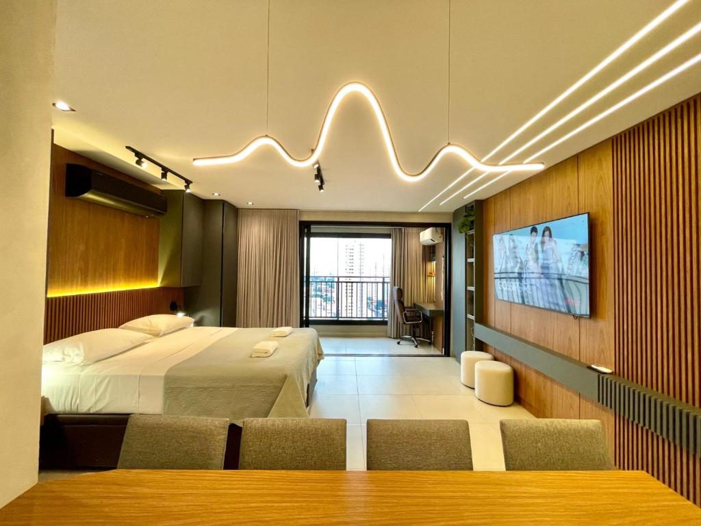 ein Hotelzimmer mit einem Bett und einem Flachbildfernseher in der Unterkunft Luxury Collection Cama Queen e Sofá Cama Separado in Campo Grande