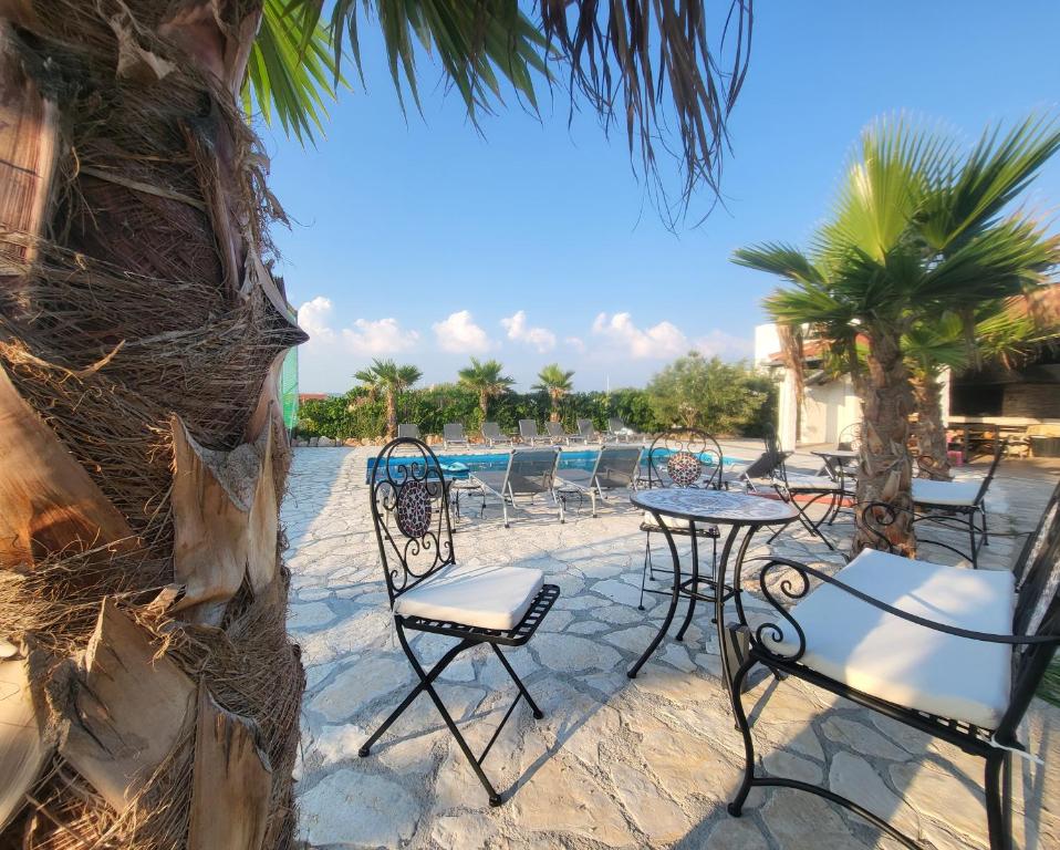 a patio with chairs and tables next to a pool at Murter Palms Resort Apartments in Murter