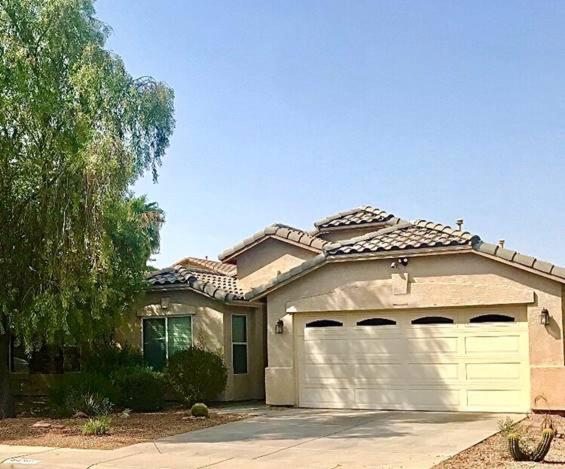 a house with a white garage door in a driveway at Palmen Maricopa in Maricopa