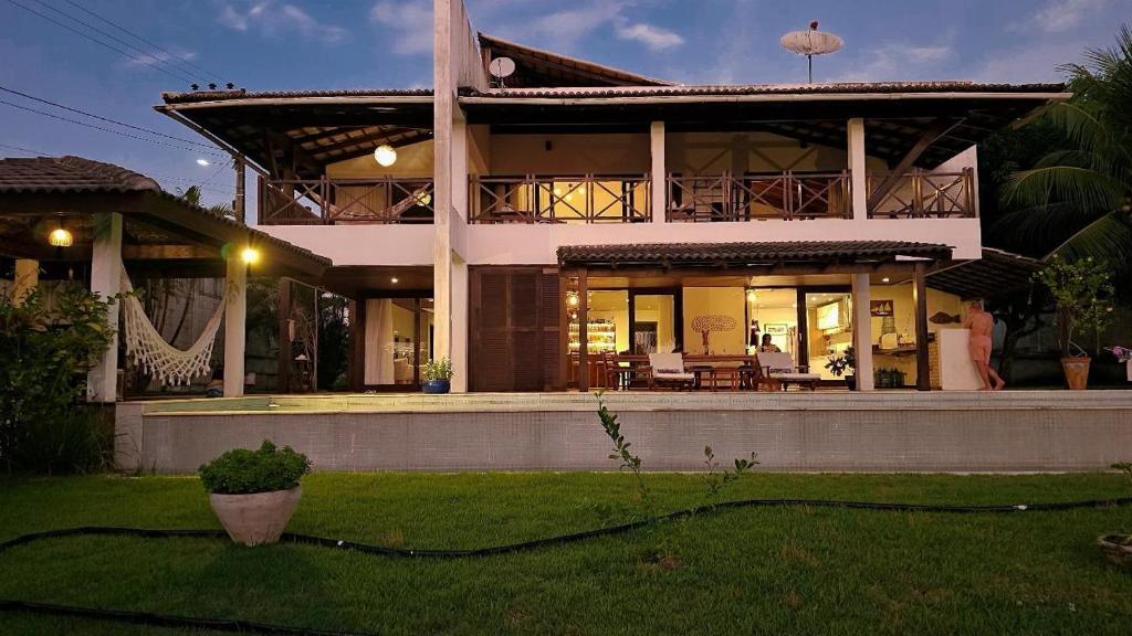 a large house with a porch and a yard at Casa Dois Mares in Pipa