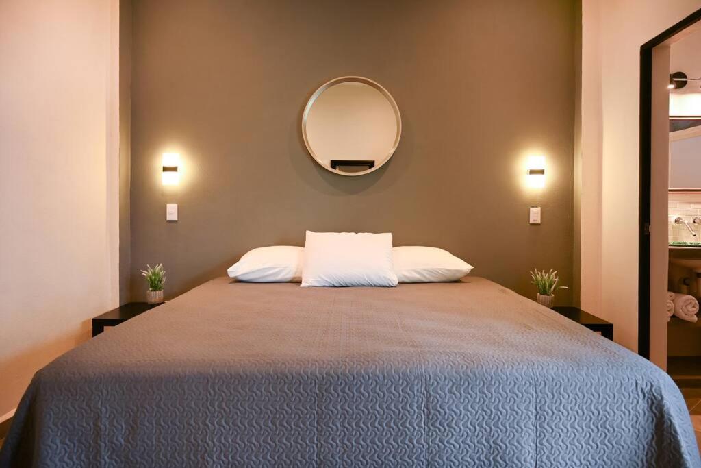 a bedroom with a large bed with a mirror on the wall at Prime Location, Fresh, Spotless, and Secure Accommodation in Sayulita