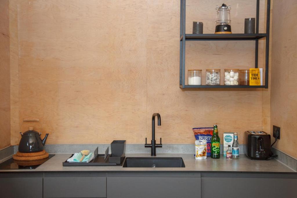 a kitchen with a sink and a counter top at Luxury Glamping Cabin with Outdoor Bath on Cornish Flower Farm in Truro
