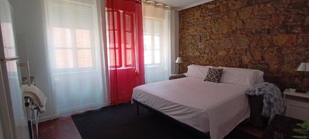 a bedroom with a bed and a brick wall at Estudio Casco Histórico II & Parking in Avilés