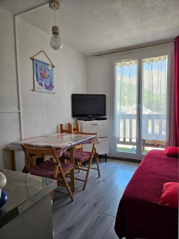 a living room with a table and a tv at studio 4 pers Puy-Saint-Vincent 1700 in Puy-Saint-Vincent