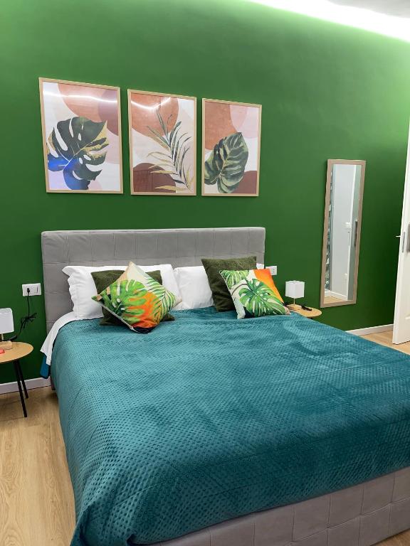 a green bedroom with a large bed with pillows at Vomero Suite and Deluxe Room B&B Napoli in Naples