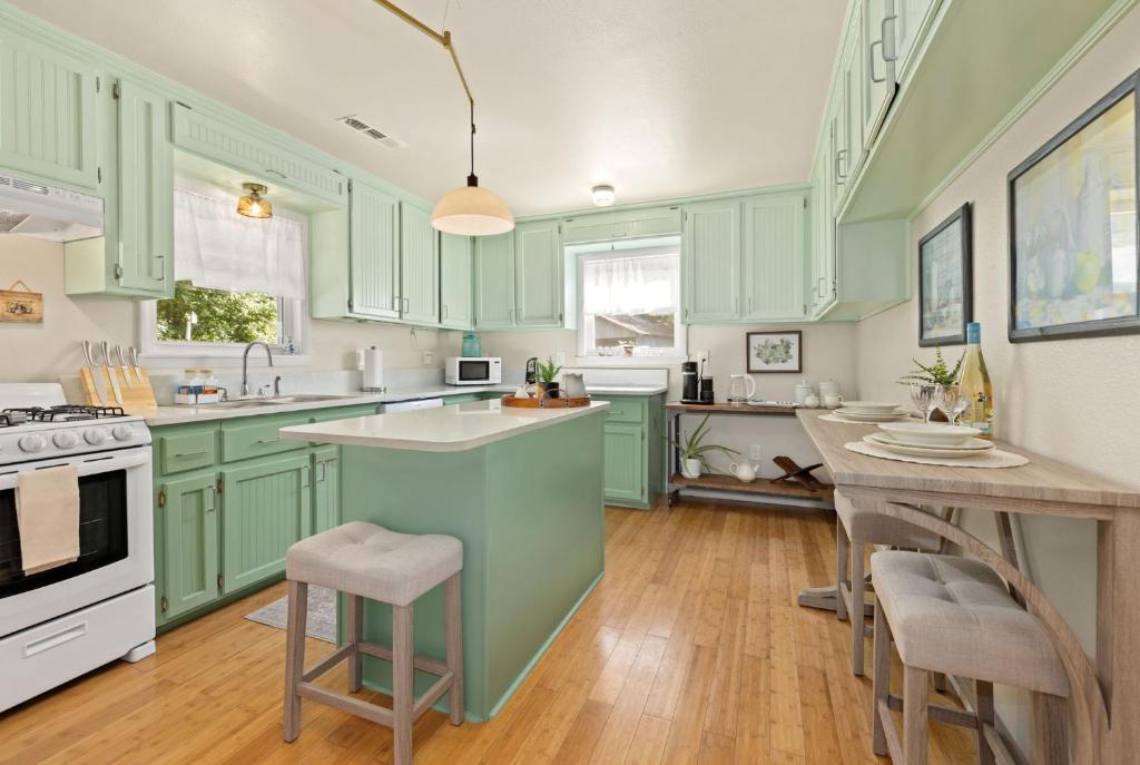 a kitchen with green cabinets and a table and chairs at Chase House at Low-Key Croft - Hot-tub - Firepit in West Fork