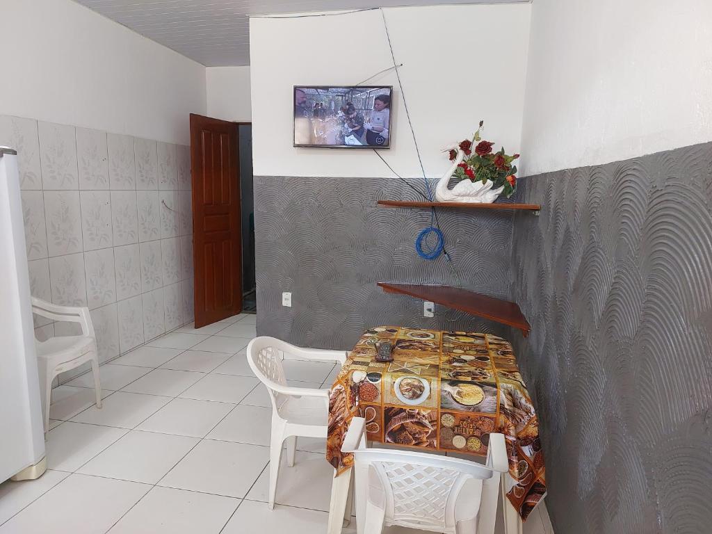 a room with a table and chairs and a wall at Casa para temporada in Belém