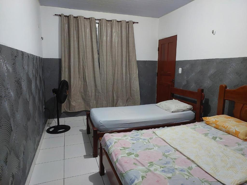 a room with two beds and a window at Casa para temporada in Belém