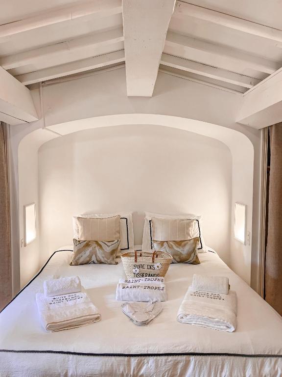 un lit blanc avec deux oreillers dessus dans l'établissement Suite des Tisserands, à Saint-Tropez
