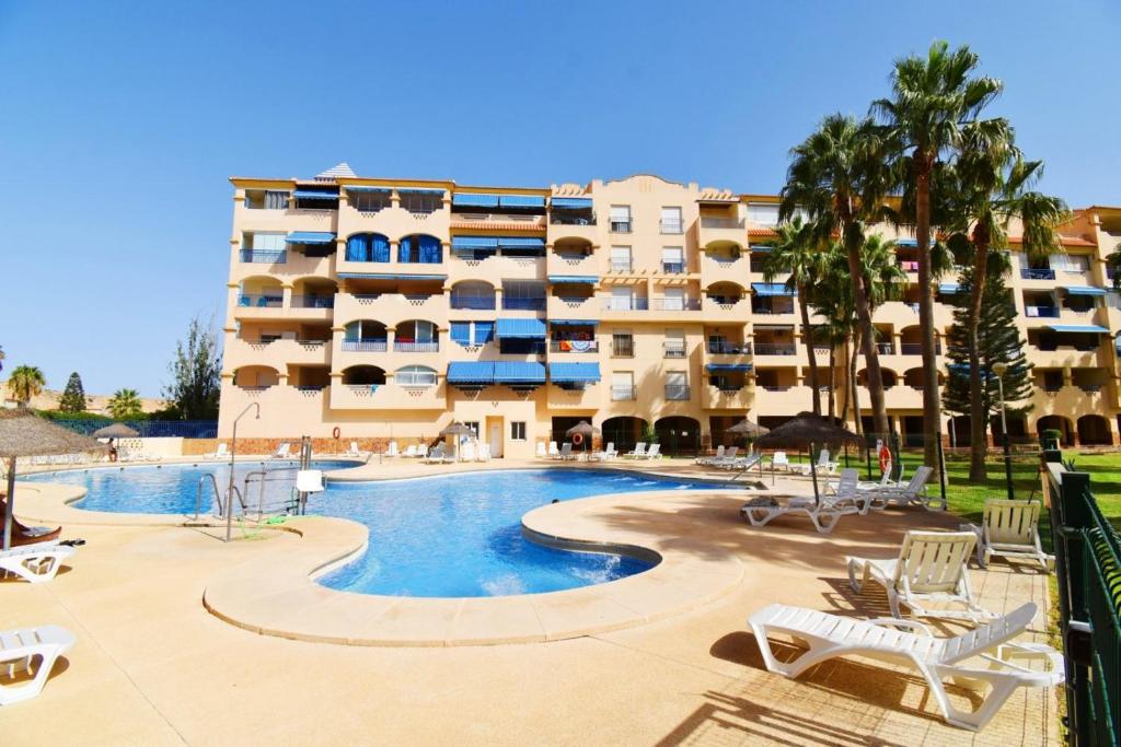 a hotel with a swimming pool and a building at Expoholidays - Estudio a pie de playa in Almerimar