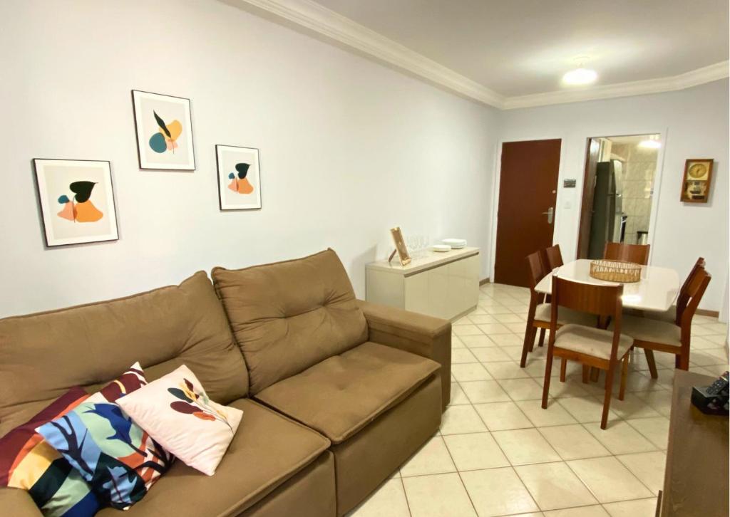 a living room with a couch and a dining room at Apartamento recantoazul es Conforto Total a 50m do Mar Apartamento Recém-Reformado na Praia de Castelhanos, ES, para 7 Pessoas Aconchegante e Completo, com 3 Quartos e 1 Suíte in Anchieta