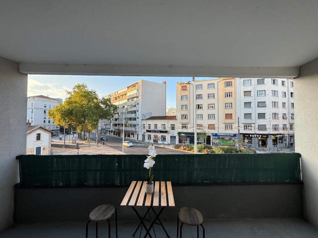un balcon avec une table et deux chaises et une fenêtre dans l'établissement Appartement Dauphiné - près de la Gare, à La Guillotière